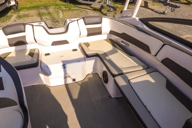 Slide: The Image of 2024 Yamaha Boats AR195 interior seating with white and gray upholstery. - 13