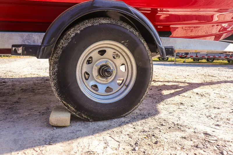 Slide: The Image of Trailer wheel of 2024 Yamaha Boats AR195 on a dirt surface. - 19