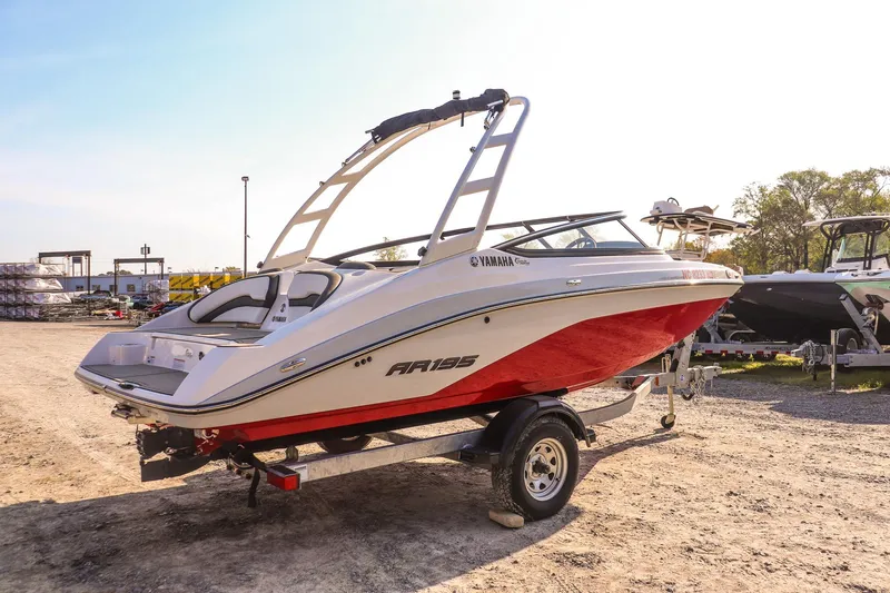 Slide: The Image of 2024 Yamaha AR195 boat with red hull on trailer in outdoor setting. - 5