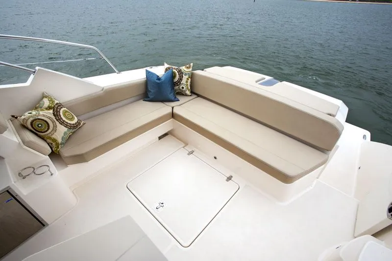 Slide: The Image of Manufacturer Provided Image: 2014 Pursuit SC 365i Sport Coupe seating area with cushions on a calm water backdrop. - 10