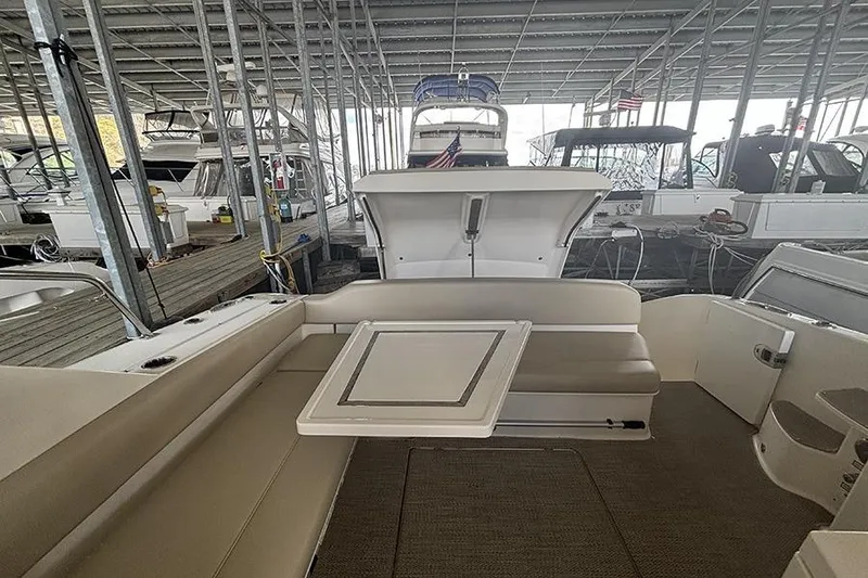 Slide: The Image of 2014 Pursuit SC 365i Sport Coupe interior with seating and table in marina. - 17