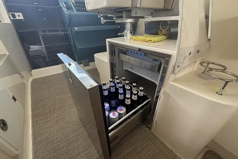 Slide: The Image of Mini fridge stocked with beverages inside a 2014 Pursuit SC 365i Sport Coupe boat. - 19