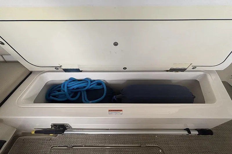 Slide: The Image of Storage compartment in 2014 Pursuit SC 365i Sport Coupe with blue rope and gear. - 25