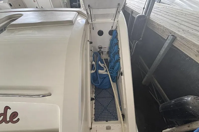 Slide: The Image of 2014 Pursuit SC 365i Sport Coupe storage compartment with blue ropes and equipment. - 27