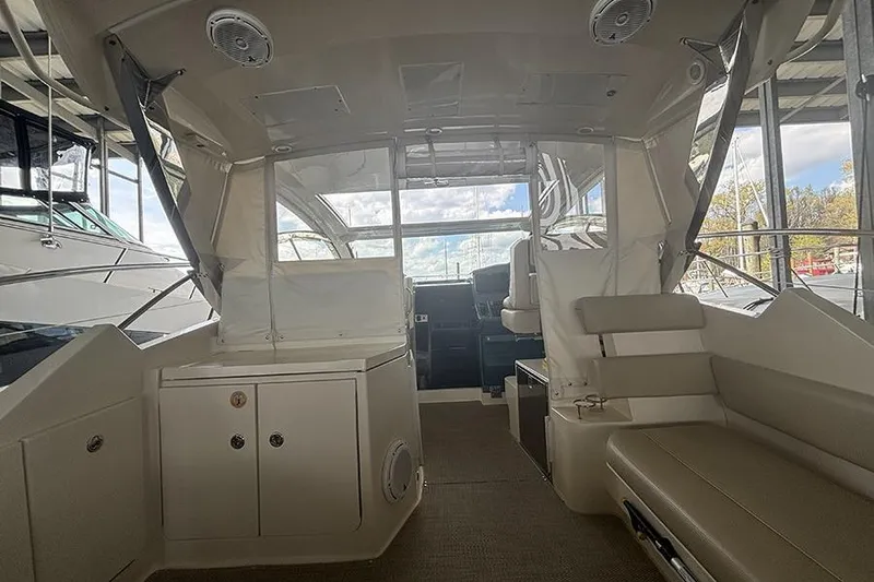 Slide: The Image of 2014 Pursuit SC 365i Sport Coupe interior with seating and helm, docked under cover. - 32