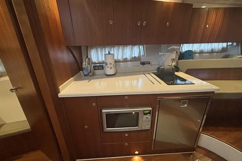 Slide: The Image of 2014 Pursuit SC 365i Sport Coupe interior kitchen with microwave, stove, and wooden cabinetry. - 41