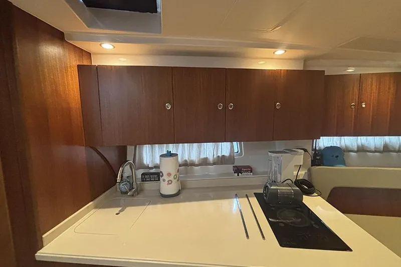 Slide: The Image of Interior of 2014 Pursuit SC 365i Sport Coupe with wooden cabinets and modern kitchen amenities. - 42