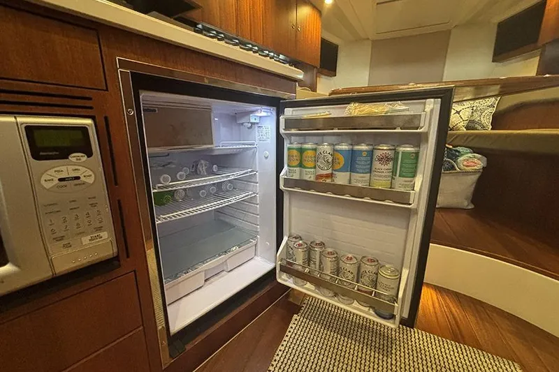 Slide: The Image of Mini fridge stocked with beverages inside a 2014 Pursuit SC 365i Sport Coupe cabin. - 45