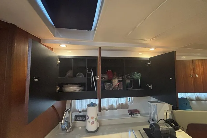 Slide: The Image of Interior of 2014 Pursuit SC 365i Sport Coupe with open kitchen cabinets. - 48