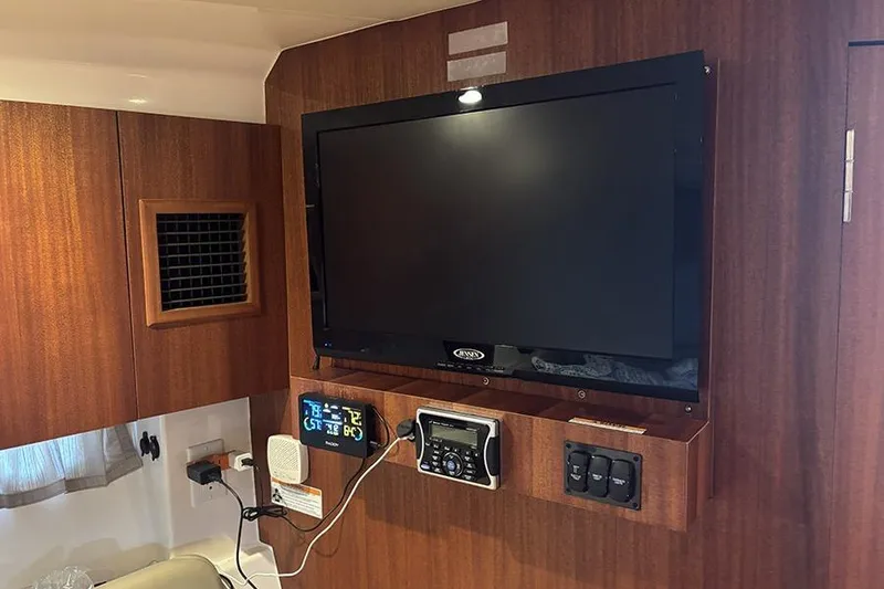 Slide: The Image of Entertainment system inside 2014 Pursuit SC 365i Sport Coupe yacht cabin. - 57