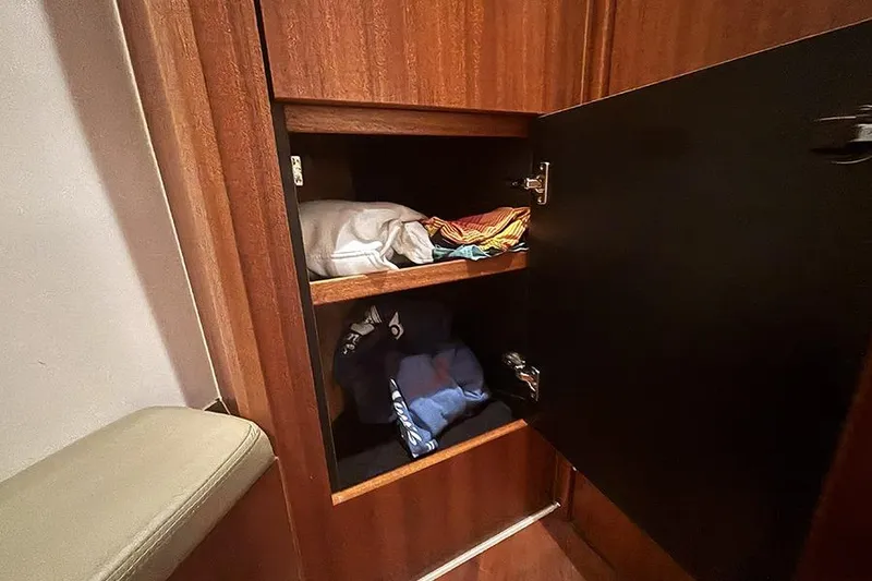 Slide: The Image of Wooden cabinet with open door, displaying neatly folded clothes inside. - 63