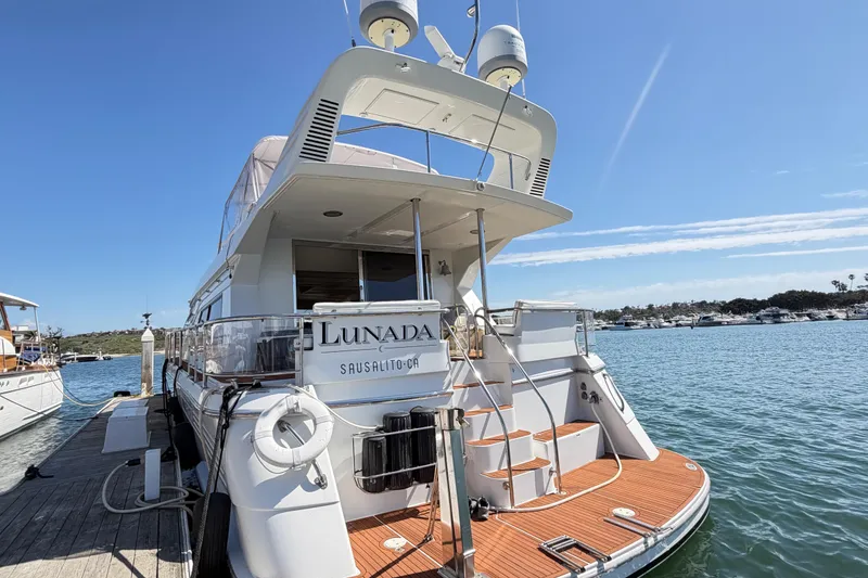 Slide: The Image of 2001 Tarrab Motor Yacht docked, featuring elegant design and spacious deck in sunny marina. - 2