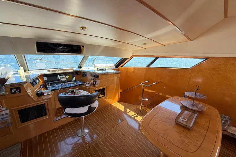 Slide: The Image of Luxurious 2001 Tarrab motor yacht interior with helm, wooden finishes, and panoramic windows. - 9