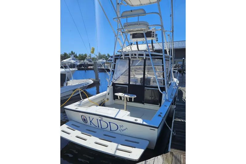Slide: The Image of 2004 Carolina Classic 28 boat docked at marina, featuring fishing tower and spacious deck. - 3