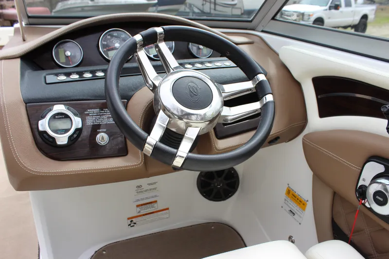 Slide: The Image of Steering wheel and dashboard of a 2012 Cobalt A25 boat, featuring modern controls. - 12