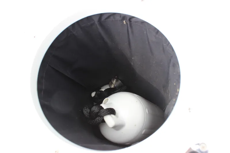 Slide: The Image of Storage compartment in 2012 Cobalt A25 boat with a white fender and black rope. - 17