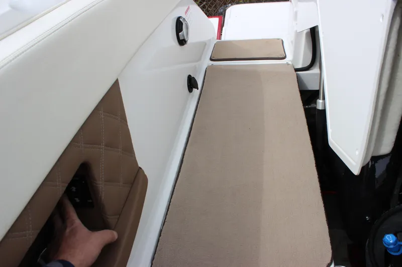 Slide: The Image of Interior view of a 2012 Cobalt A25 boat, featuring cushioned seating and storage access. - 25