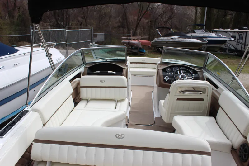 Slide: The Image of 2012 Cobalt A25 boat interior with white seating and steering console. - 32