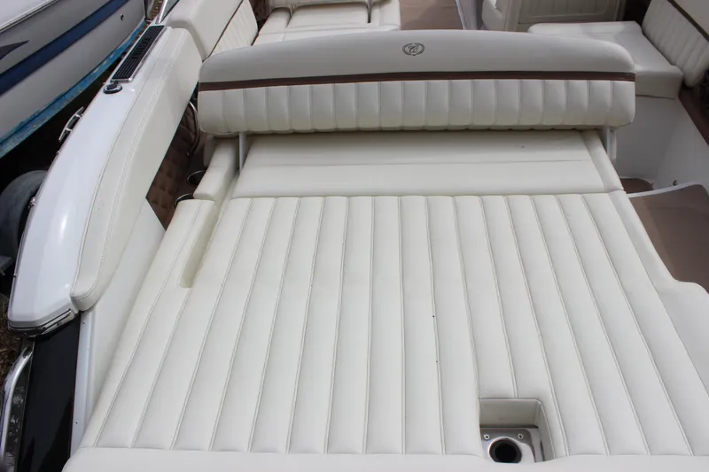 Slide: The Image of 2012 Cobalt A25 boat interior with white cushioned seating and sleek design. - 33