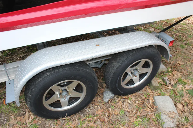 Slide: The Image of Trailer wheels and fender of a 2012 Cobalt A25 boat on grass. - 35