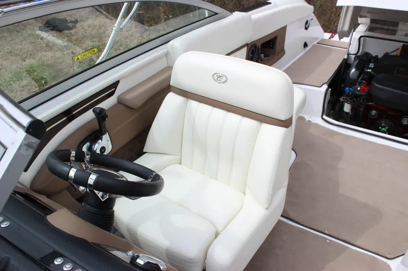 Slide: The Image of 2012 Cobalt A25 boat interior with white captain's seat and visible engine compartment. - 6