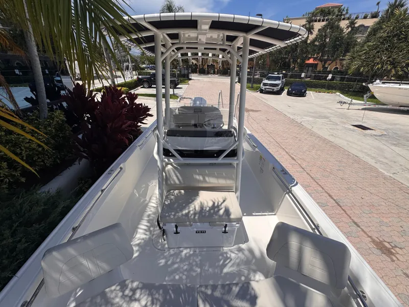 Slide: The Image of The image shows a 2026 Boston Whaler 210 Montauk boat on a paved area with palm trees in the background. - 29