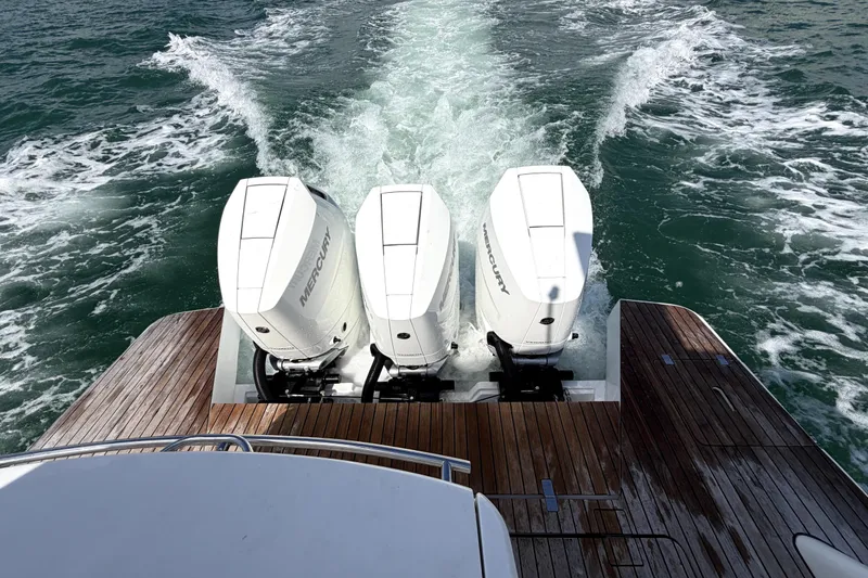 Slide: The Image of Triple Mercury outboard engines on 2024 Schaefer 400 yacht, cruising through ocean waters. - 2