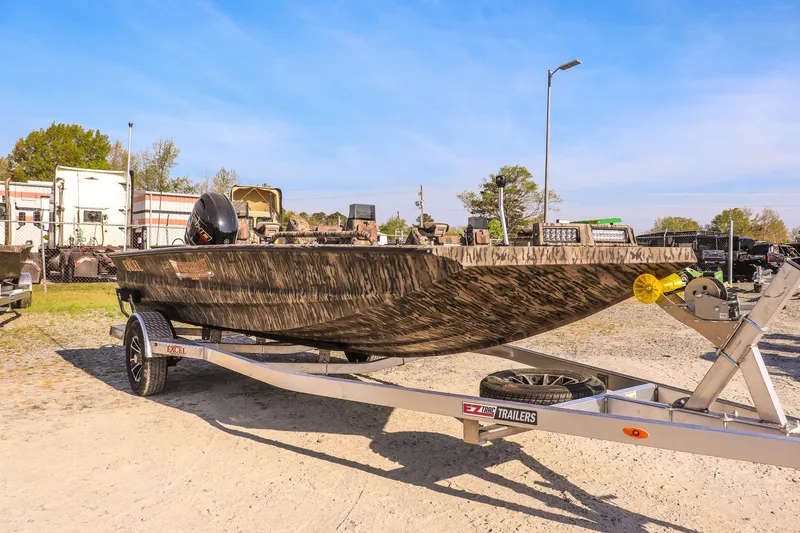 The Image of 2026 Excel 183 Tomahawk boat on trailer, camo design, outdoor setting. - 1