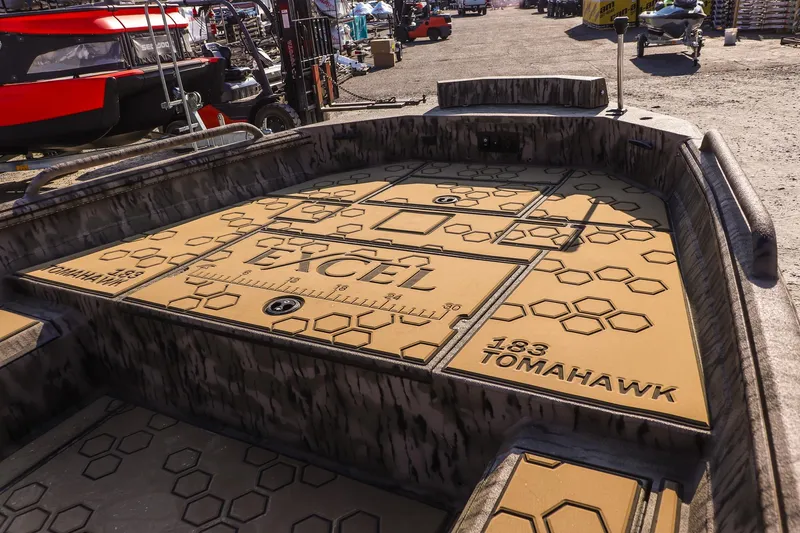 Slide: The Image of 2026 Excel 183 Tomahawk boat interior with hexagonal pattern and branding. - 12