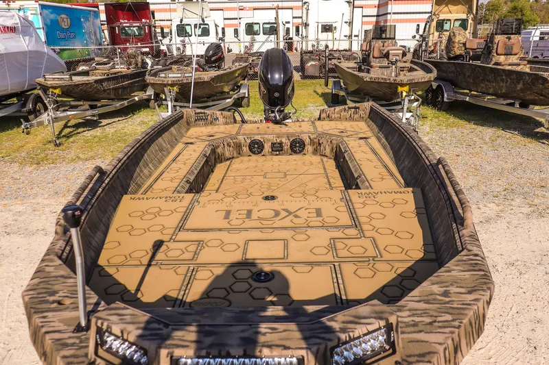 Slide: The Image of 2026 Excel 183 Tomahawk boat displayed outdoors with camouflage design. - 9