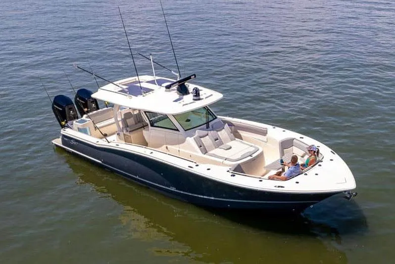 Slide: The Image of Manufacturer Provided Image: 2025 Scout 400 LXF Li-Ion boat on calm water, featuring luxury design and multiple outboard engines. - 1