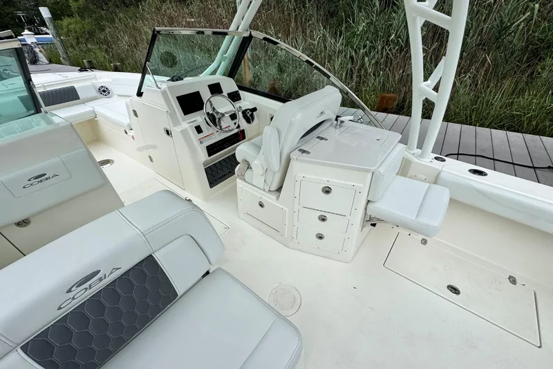 Slide: The Image of 2026 Cobia 240 Dual Console boat interior with helm, seating, and storage compartments. - 11