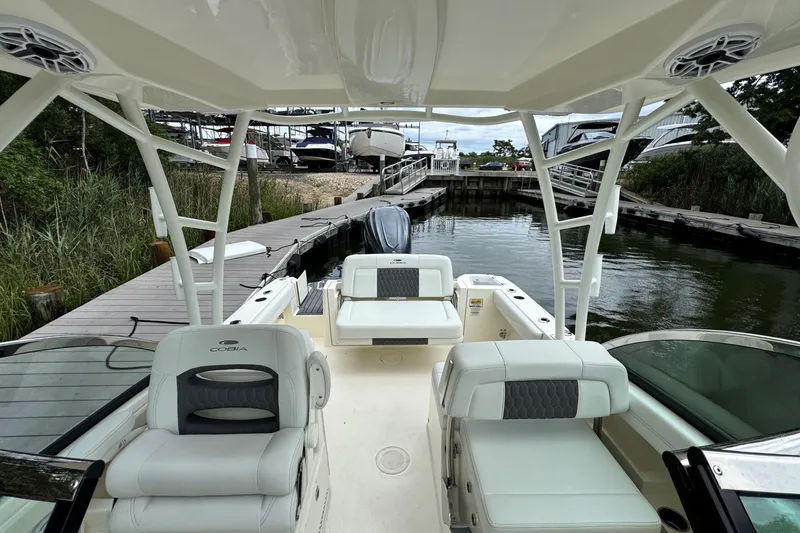 Slide: The Image of 2026 Cobia 240 Dual Console boat docked, featuring spacious seating and modern design. - 14