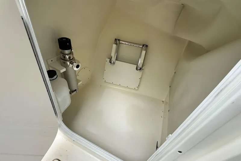 Slide: The Image of Interior of 2026 Cobia 240 Dual Console boat, featuring storage compartment and ladder. - 16