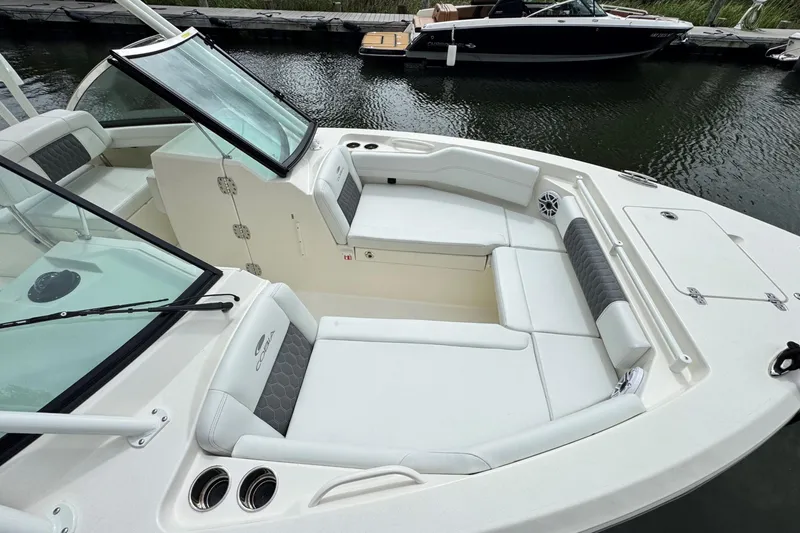 Slide: The Image of 2026 Cobia 240 Dual Console boat interior with cushioned seating and windshield. - 17