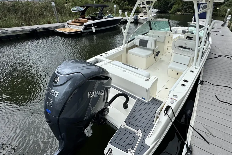 Slide: The Image of 2026 Cobia 240 Dual Console boat docked with Yamaha 350 V8 engine. - 3