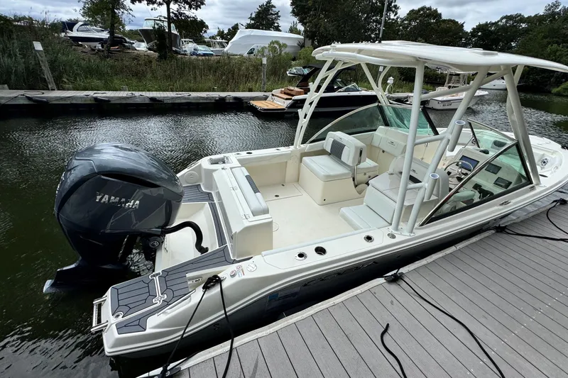 Slide: The Image of 2026 Cobia 240 Dual Console boat docked, featuring Yamaha outboard motor. - 4
