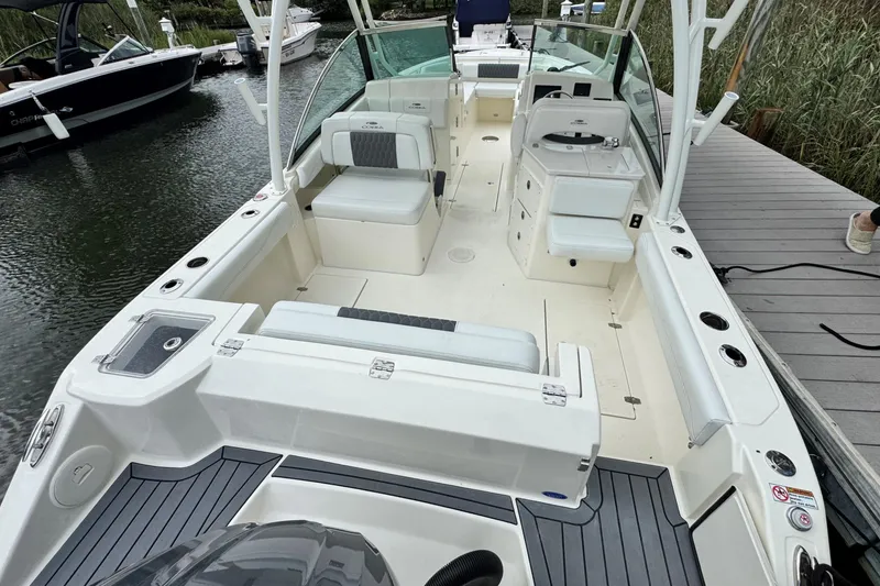 Slide: The Image of 2026 Cobia 240 Dual Console boat docked, featuring spacious seating and modern design. - 5
