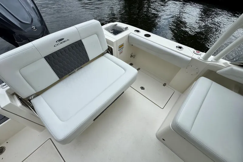 Slide: The Image of 2026 Cobia 240 Dual Console boat interior with cushioned seating and water view. - 7