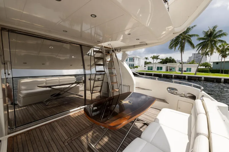 Slide: The Image of Luxurious 1999 Azimut 58 yacht deck with seating, table, and waterfront view. - 10