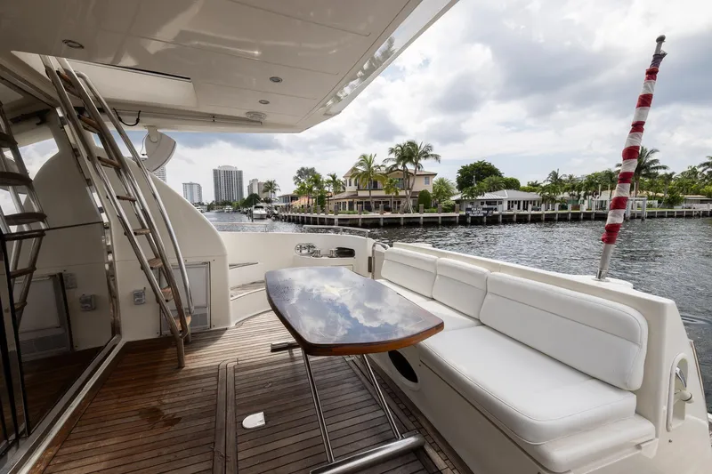 Slide: The Image of Luxurious 1999 Azimut 58 yacht deck with seating, table, and waterfront view. - 11