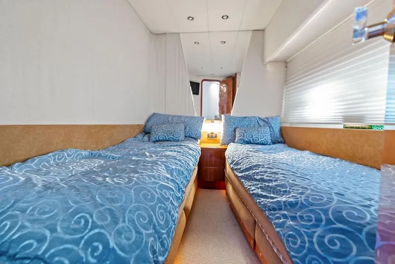 Slide: The Image of Interior of 1999 Azimut 58 yacht with twin beds and blue bedding. - 21