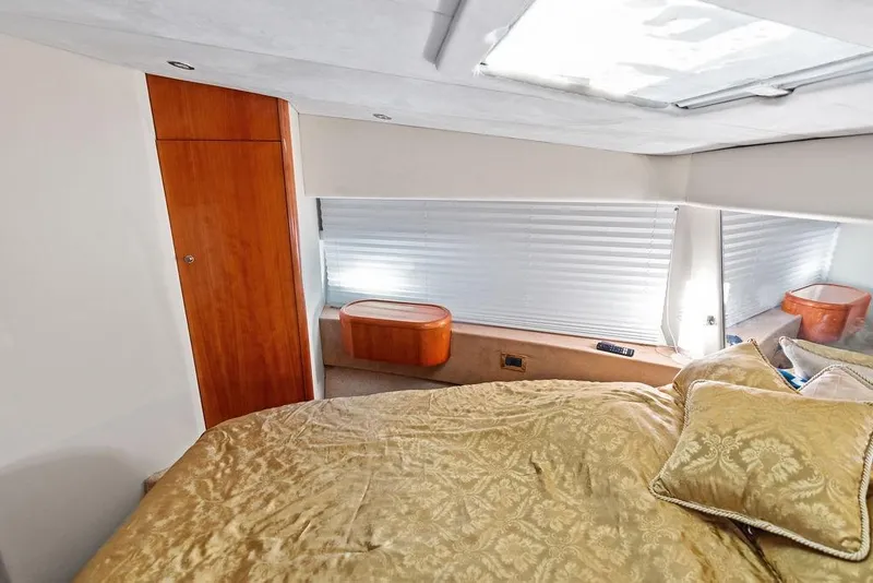 Slide: The Image of Luxurious bedroom interior of a 1999 Azimut 58 yacht with elegant bedding and wooden accents. - 28