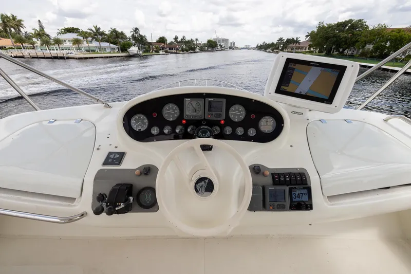Slide: The Image of 1999 Azimut 58 yacht helm with navigation instruments and waterway view. - 43