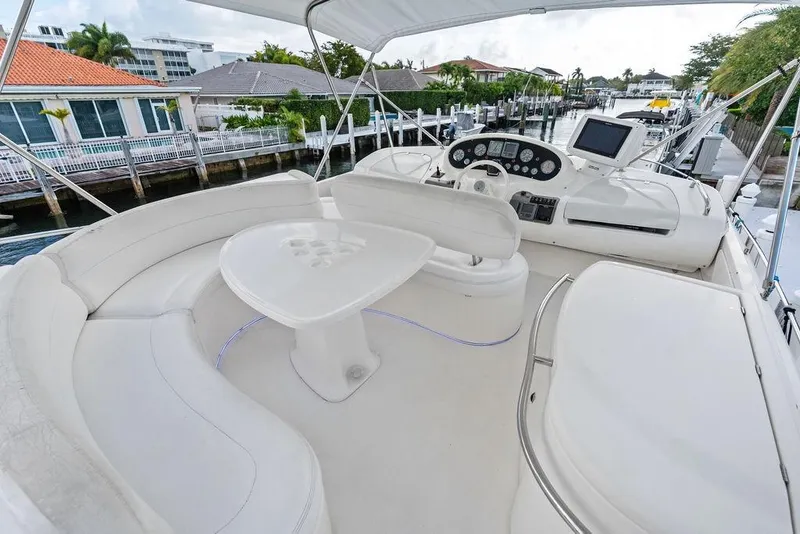 Slide: The Image of Flybridge of a 1999 Azimut 58 yacht with white seating and control panel. - 44