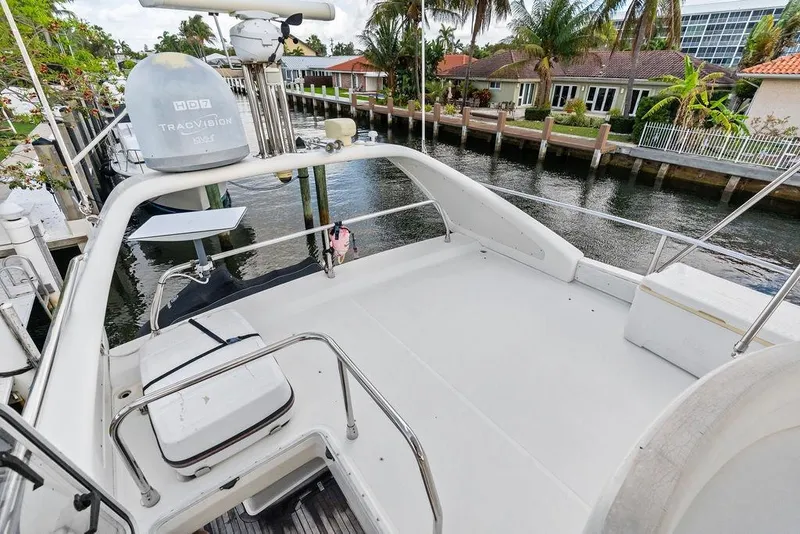 Slide: The Image of 1999 Azimut 58 yacht deck with satellite equipment, docked by waterfront homes. - 46