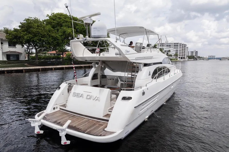 Slide: The Image of 1999 Azimut 58 yacht on water, featuring sleek design and spacious deck. - 5