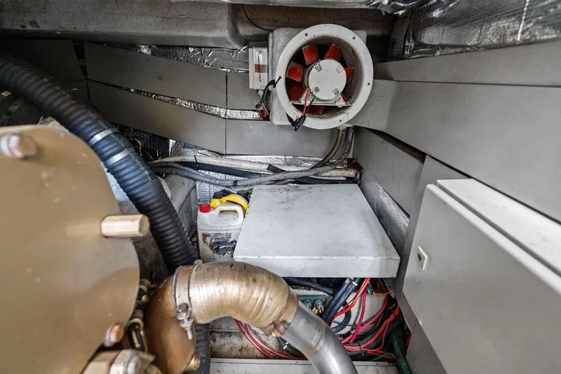 Slide: The Image of Engine room of a 1999 Azimut 58 yacht, featuring mechanical components and wiring. - 56