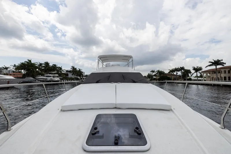 Slide: The Image of 1999 Azimut 58 yacht on water, cloudy sky, palm trees in background. - 7