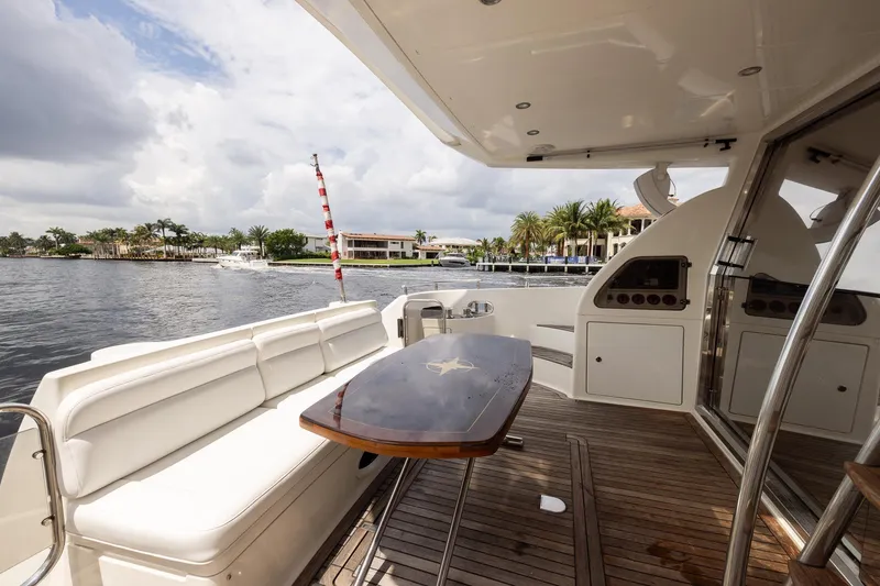 Slide: The Image of Luxury yacht Azimut 58, 1999 model, featuring elegant deck seating and scenic waterfront view. - 9